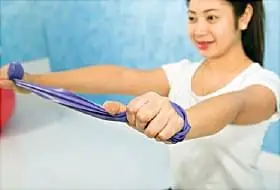 женщина тренируется с эспандером