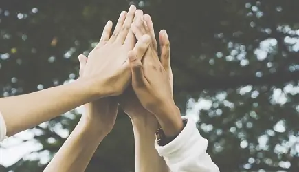 Four hands raised in the air Four hands raised in the air