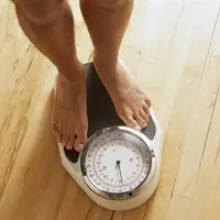 Man weighing himself on a scale