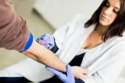 Healthcare worker drawing blood from man's arm