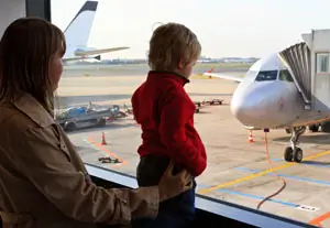 Mother and child looking at planes through an airport window Mother and child looking at planes through an airport window