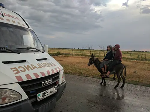 Дети катаются на ослике домой в конце рабочего дня в учебном районе Жамбылской области