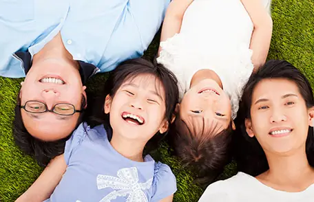Family lying on grass and smiling Family lying on grass and smiling