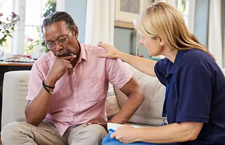 Photo of therapist talking to man who appears to be depressed