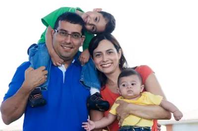 Mom holding baby. Dad with toddler on his back Mom holding baby. Dad with toddler on his back