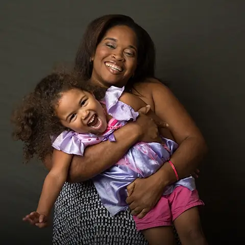 woman holding her young daughter smiling woman holding her young daughter smiling