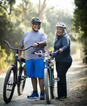 Латиноамериканский мужчина и женщина, стоящая с велосипедами