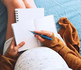 A pregnant woman taking notes