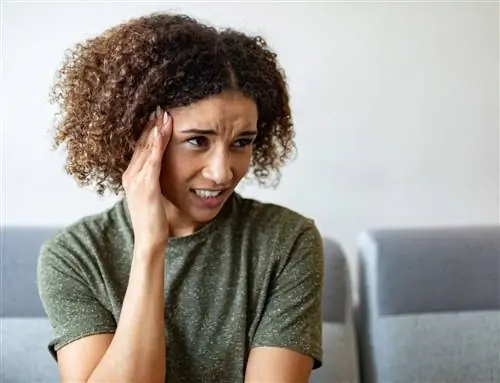 Человек с анкилозирующим спондилитом на диване чувствует головокружение