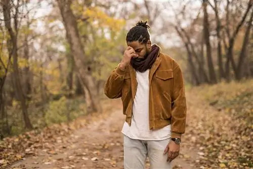 Человек с головной болью на улице