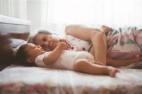 Бабушка лежит в постели с ребенком