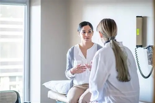 Молодая женщина разговаривает с врачом.