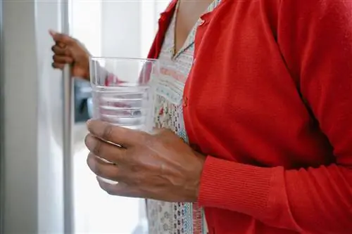 Женщина получает стакан воды из-за повышенной жажды от диабета