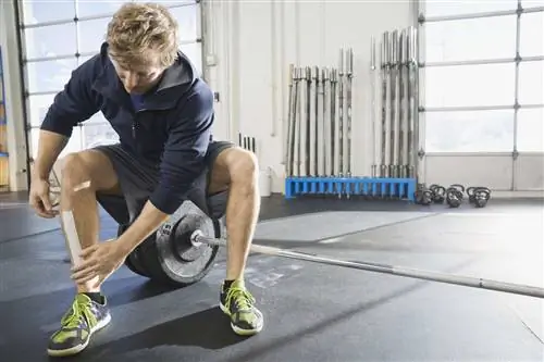 Мужчина накладывает кинезиологическую ленту на голени