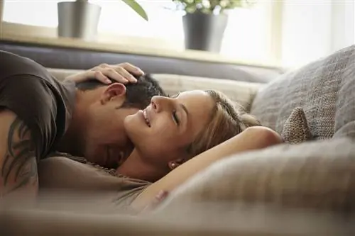 Молодая пара обнимается на диване