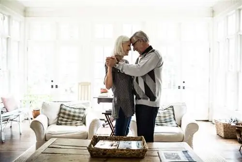 Пожилая пара танцует в гостиной