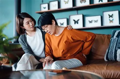 Женщина утешает мать, которая чувствует боль в крестцово-подвздошном суставе