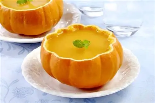 Нарезанная открытая тыква с апельсиновым пудингом внутри.