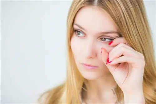 Женщина на белом фоне чешет уголок глаза