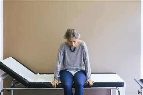 пожилая женщина сидит на столе у врача