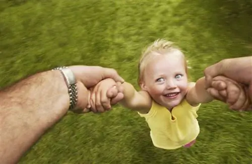 взрослый мужчина качает молодую девушку за руки