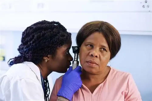 Женщина с болью в ухе проходит обследование уха