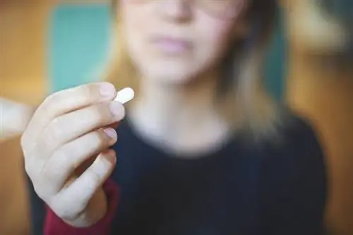 женщина принимает витамин