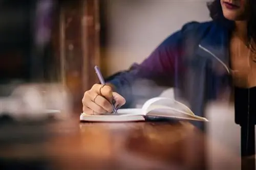 Женщина пишет в блокноте