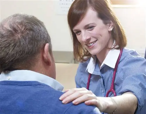 Врач общей практики кладет руку на плечо пациента в хирургии