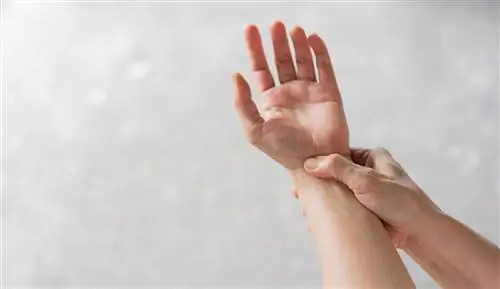 крупным планом массаж пожилой женщины под рукой, чтобы облегчить боль от тяжелой работы для лечения синдрома запястного канала и концепции здравоохранения хронических заболеваний