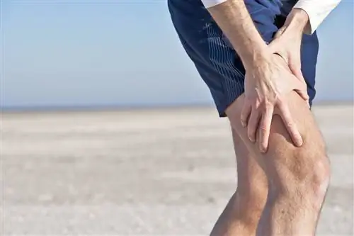 Фотография мужчины, держащего больное бедро.