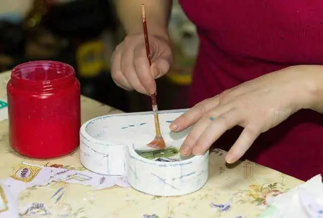 Женщина украшает коробку в форме сердца