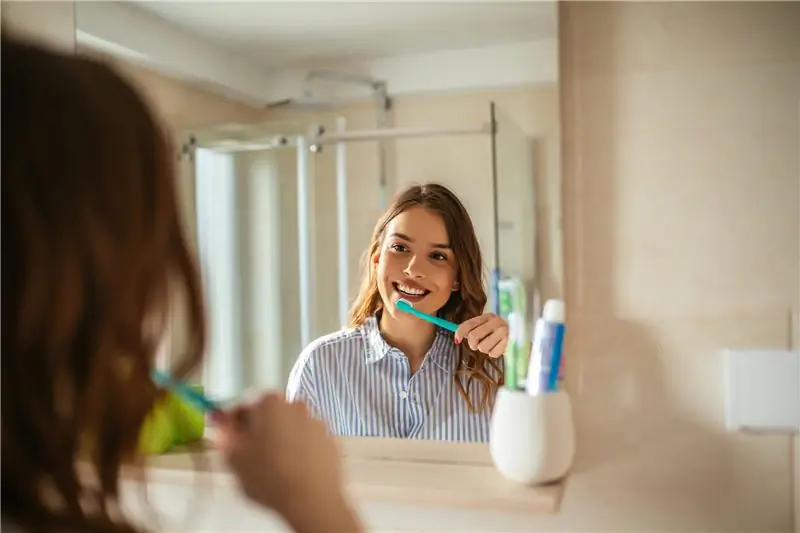 Женщина чистит зубы