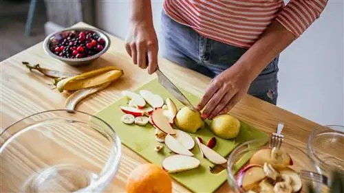 женщина режет фрукты для фруктового салата