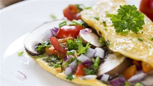 овощной белковый омлет на белой тарелке, помидоры, грибы, красный лук, кинза