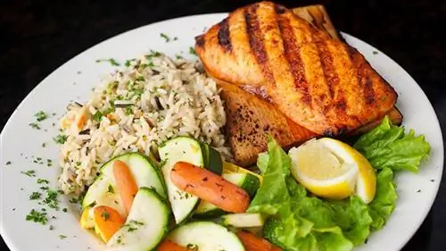 рис с лососем и овощи на тарелке