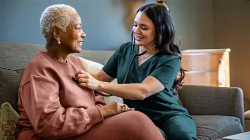 Медсестра проверяет жизненные показатели пожилой женщины в ее доме