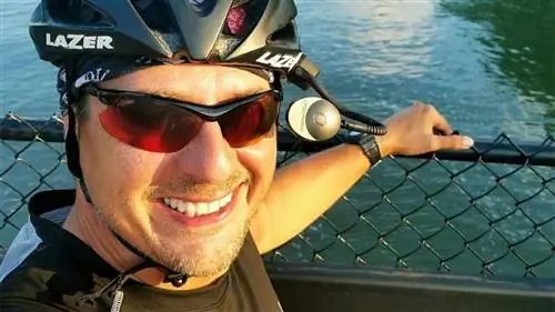 Тодд Робертсон в шлеме и солнцезащитных очках на улице у воды
