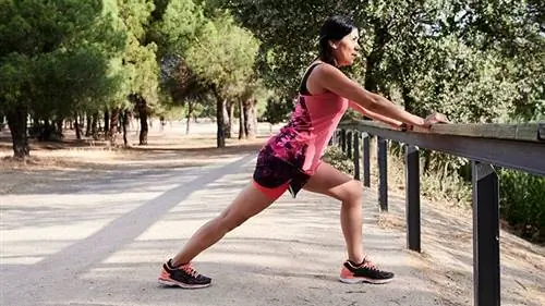 женщина вытягивает ноги у барной стойки на улице