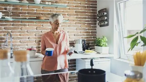 женщина на кухне с чаем и телефоном