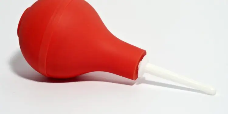 Шприц для клизмы, красный шарик и белая трубка для клизмы