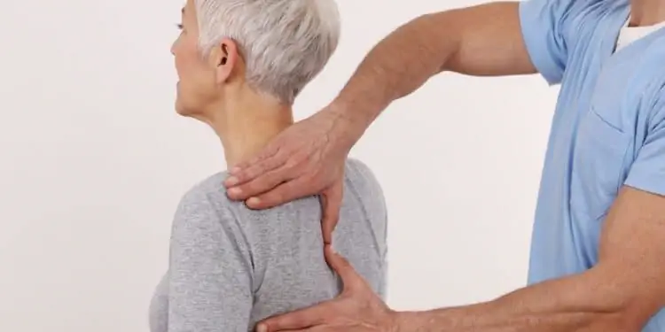 Хиропрактик пальпирует позвоночник пациента